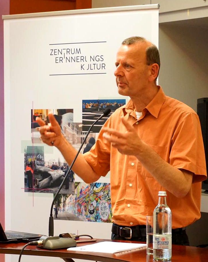 Das Bild zeigt Prof. Klausmeier wie er während seines Vortrags unterstreichend mit den Händen gestikuliert. 